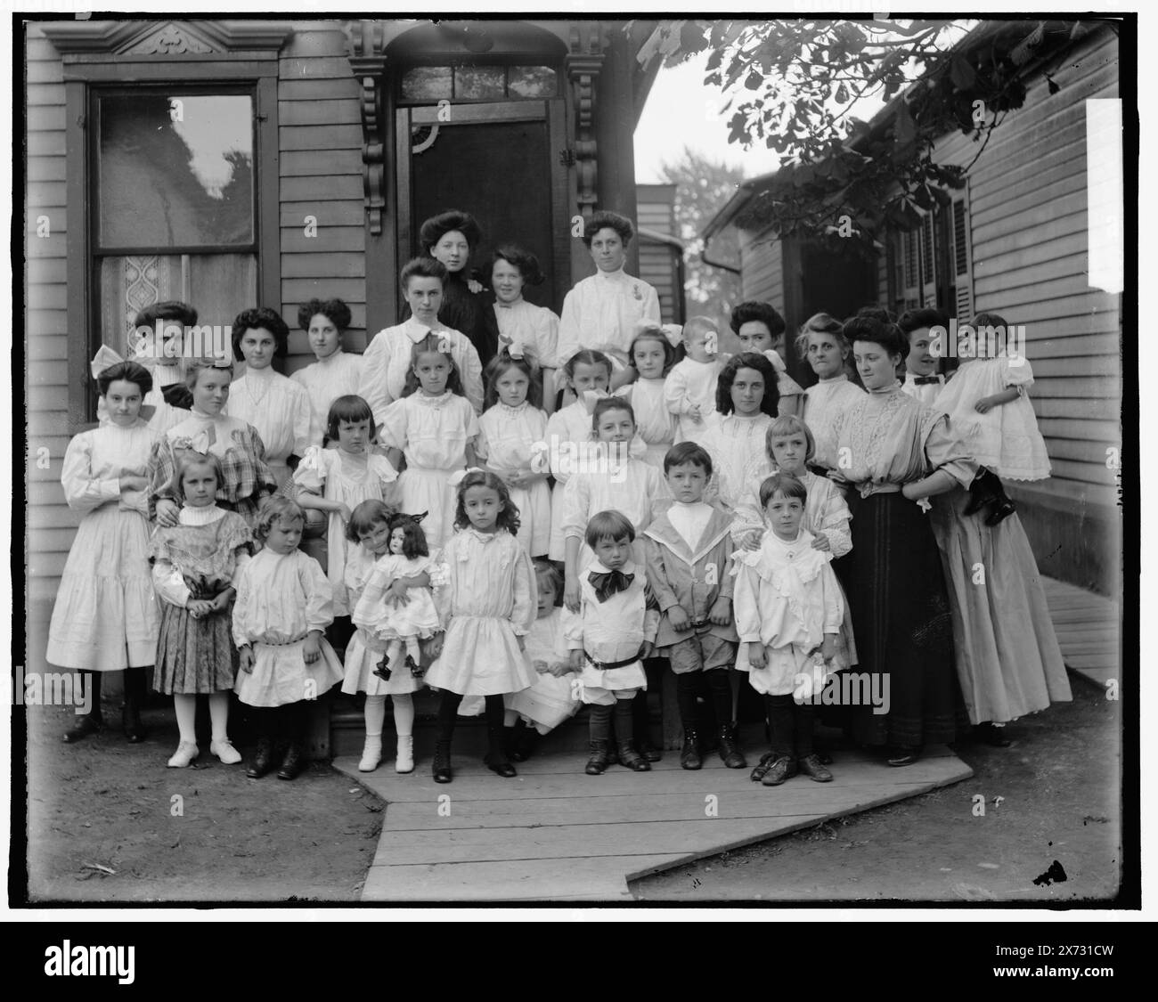 Kinder und Frauen vor dem Haus, evtl. Schulkinder und Lehrer, Titel vom Kataloger erdacht., 'Mrs. R. Jacque' und '2027' auf negativ., Detroit Publishing Co.-Nr. X 187., Geschenk; State Historical Society of Colorado; 1949, Kinder & Erwachsene. Stockfoto