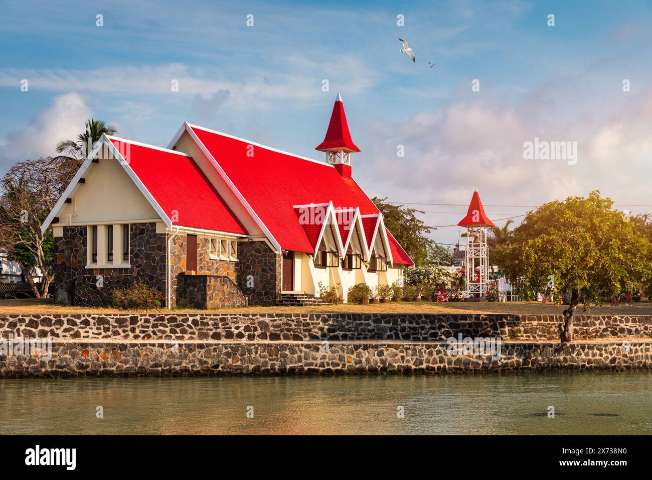 Rote Kirche im Dorf Cap Malheureux auf Mauritius. Notre Dame de Auxiliatrice, ländliche Kirche mit rotem Dach im tropischen Dorf Cap Malheureux auf M Stockfoto