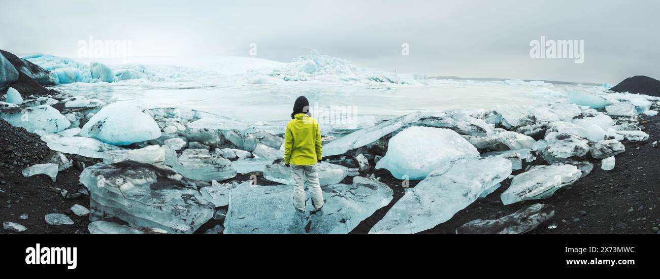 Nahaufnahme der Gletscherlagune Fjallsjokull mit Person steht auf dem Eisberg. Die wunderbare Gletscherlagune von Fjallsrln in Island schmilzt Stockfoto