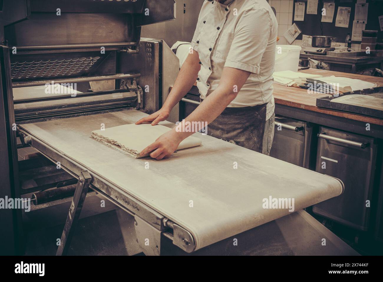 Automatische Teigmaschine zum Aufrollen von Teig zur Herstellung von Blätterteig. Französisches Croissant-Verfahren. Stockfoto