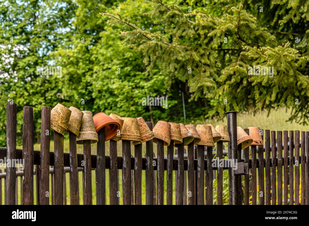Holzzaun mit Blumentöpfen oben Stockfoto