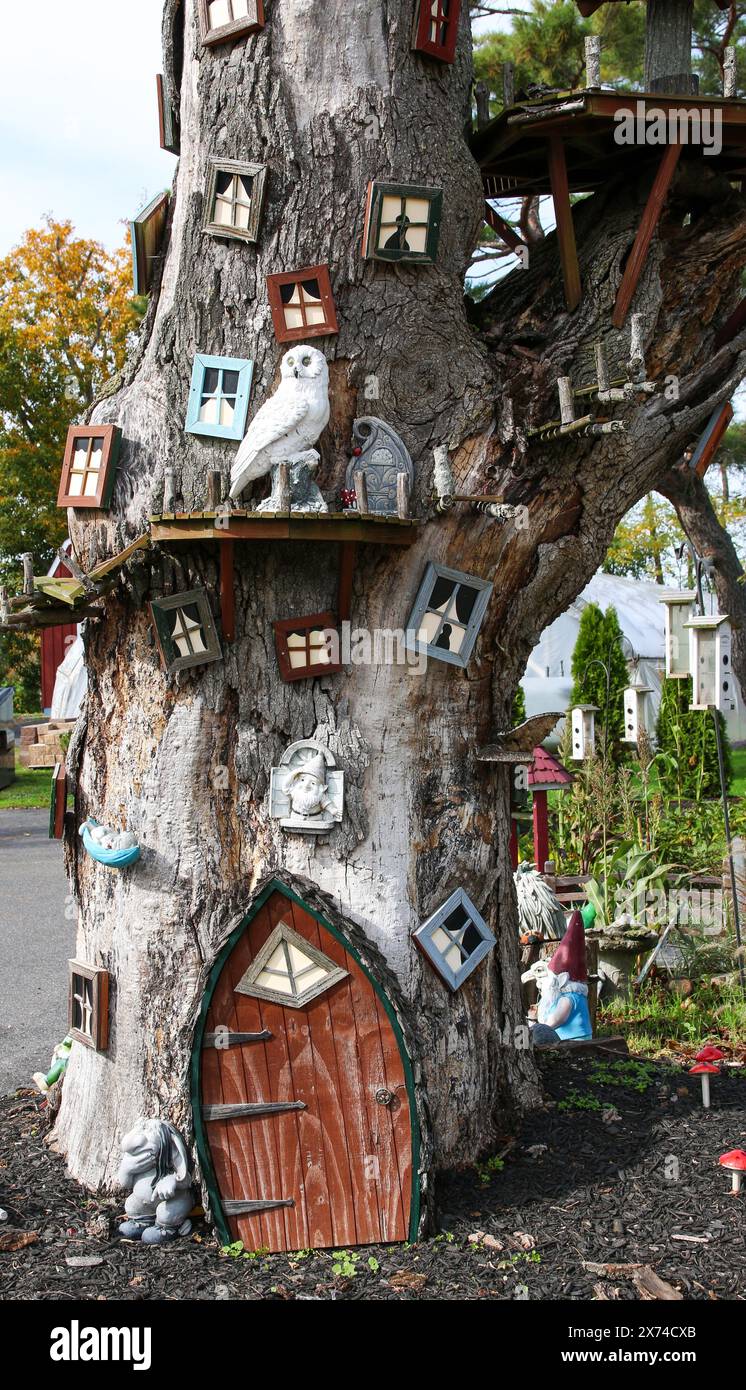 Ein Baum integriert eine Hausstruktur nahtlos in seinen Stamm und seine Äste und schafft so eine einzigartige Mischung aus Architektur und Natur. Stockfoto