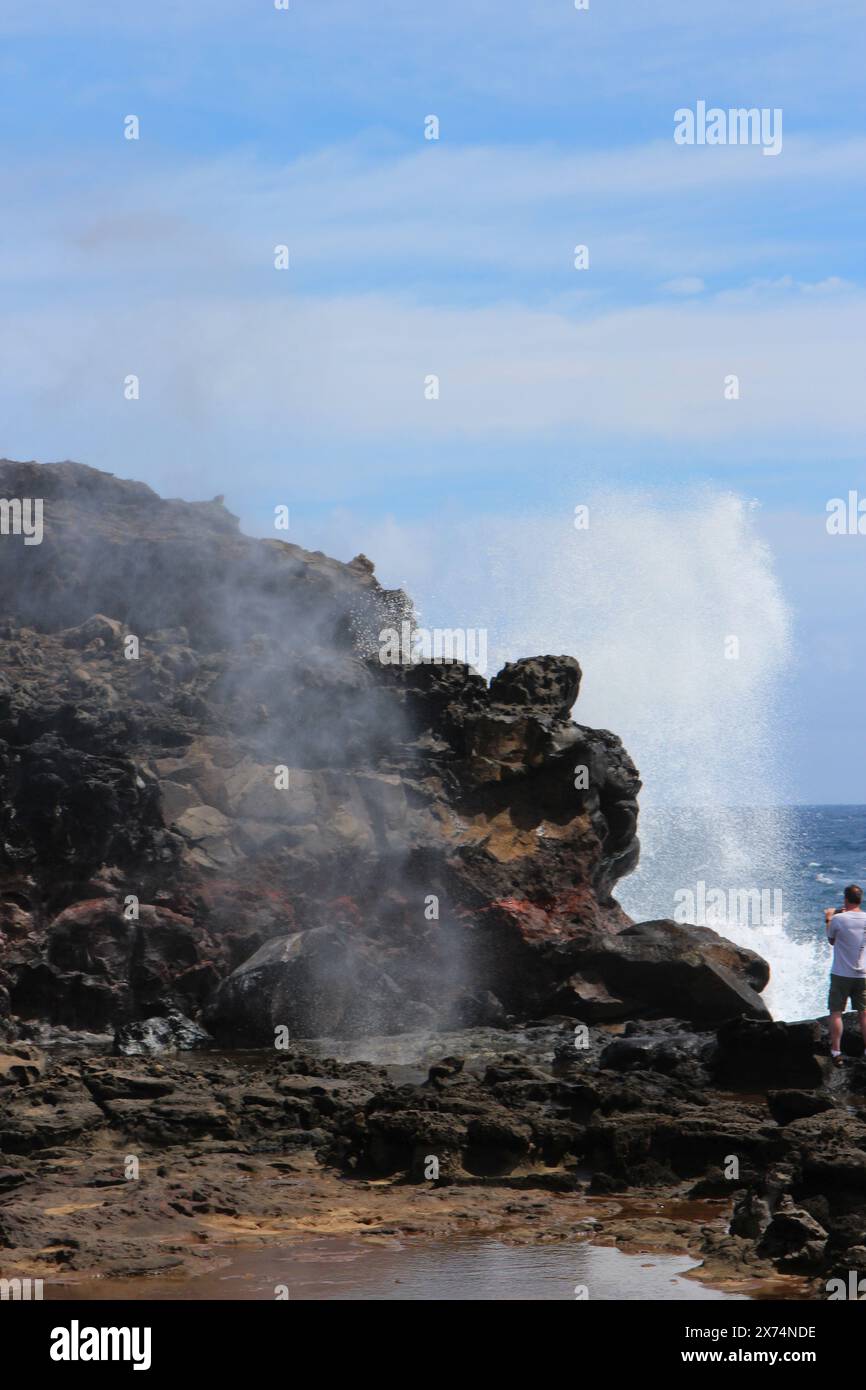 Ein Mann, der gefährlich nahe am Nakalele Blowhole steht und versucht, ein Foto in Maui, Hawaii, USA, zu machen Stockfoto