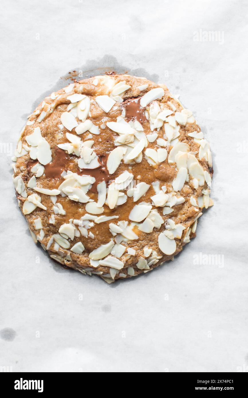 Blick von oben auf Mandelschokolade-Chip-Cookies, in Scheiben geschnittene Mandelschokolade-Chip-Cookies auf Pergamentpapier Stockfoto