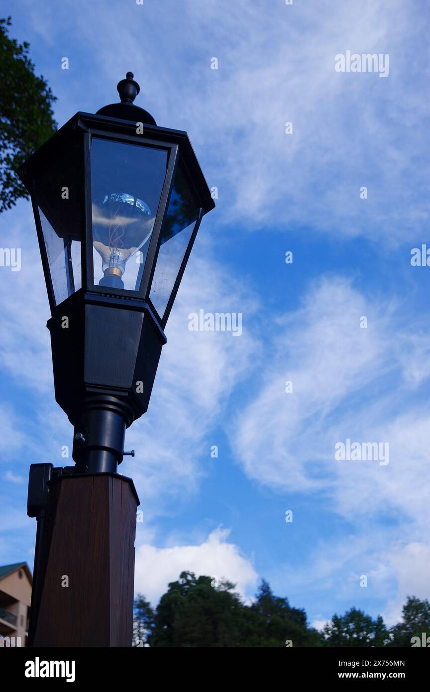Schwarzer Lampenpfosten gegen einen blauen Himmel Stockfoto