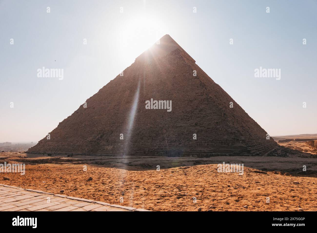 Die Sonne richtet sich perfekt über die Spitze der Großen Pyramide von Gizeh aus, wirft einen Lichtstrahl durch ihr Gesicht und beleuchtet das umliegende Wüstenland Stockfoto