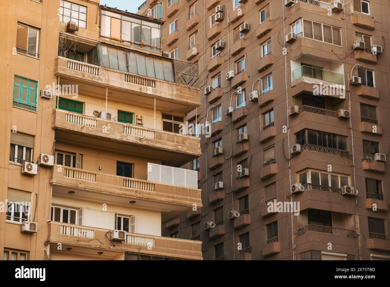 Außenansicht der verwitterten, hohen Apartmenthäuser in Kairo mit zahlreichen Balkonen und externen Klimaanlagen Stockfoto
