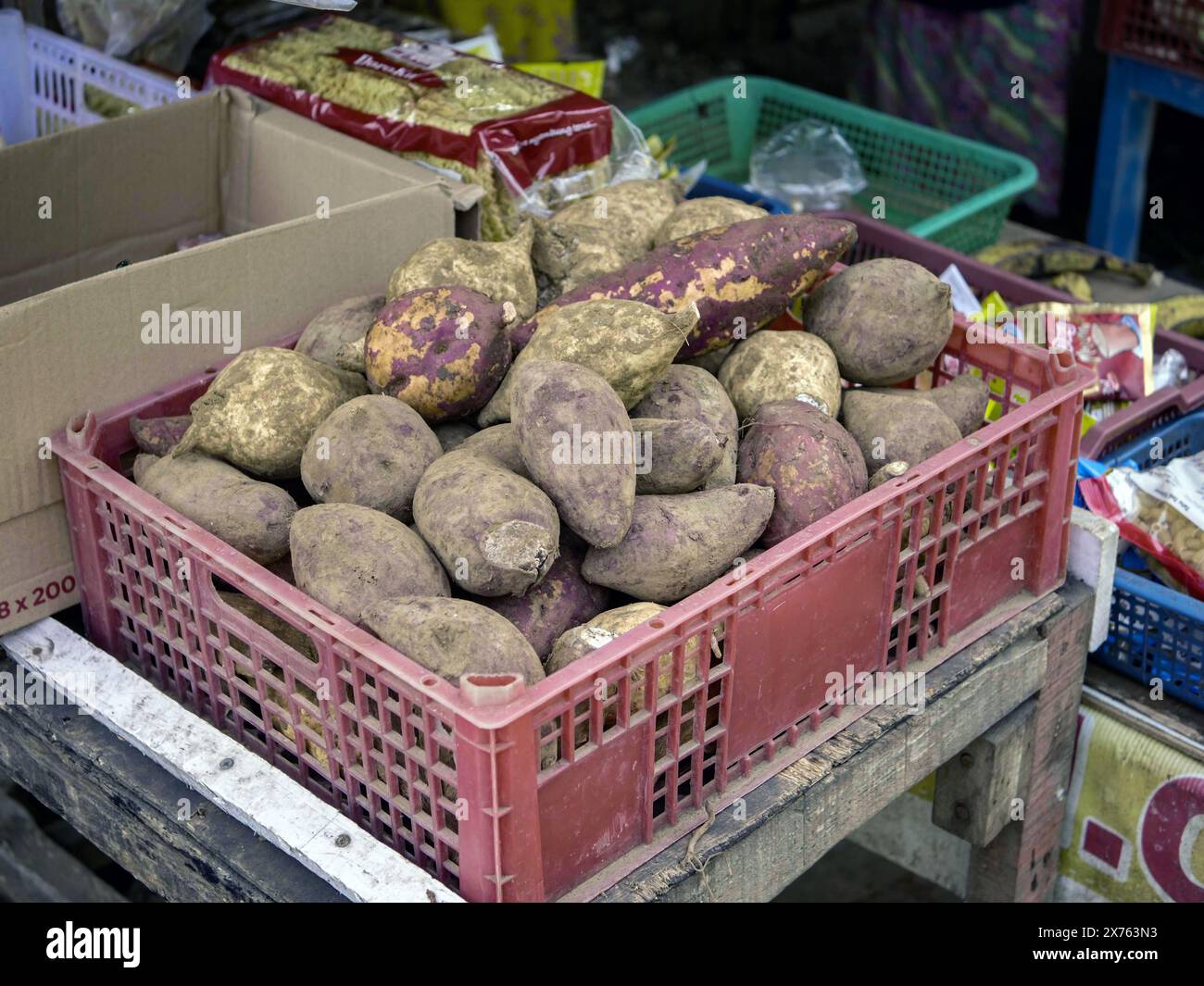 Jakarta, Indonesien - 6. Mai 2024 : Nahaufnahme von Süßkartoffeln in einer Plastikkiste mit anderen Lebensmitteln im Hintergrund Stockfoto