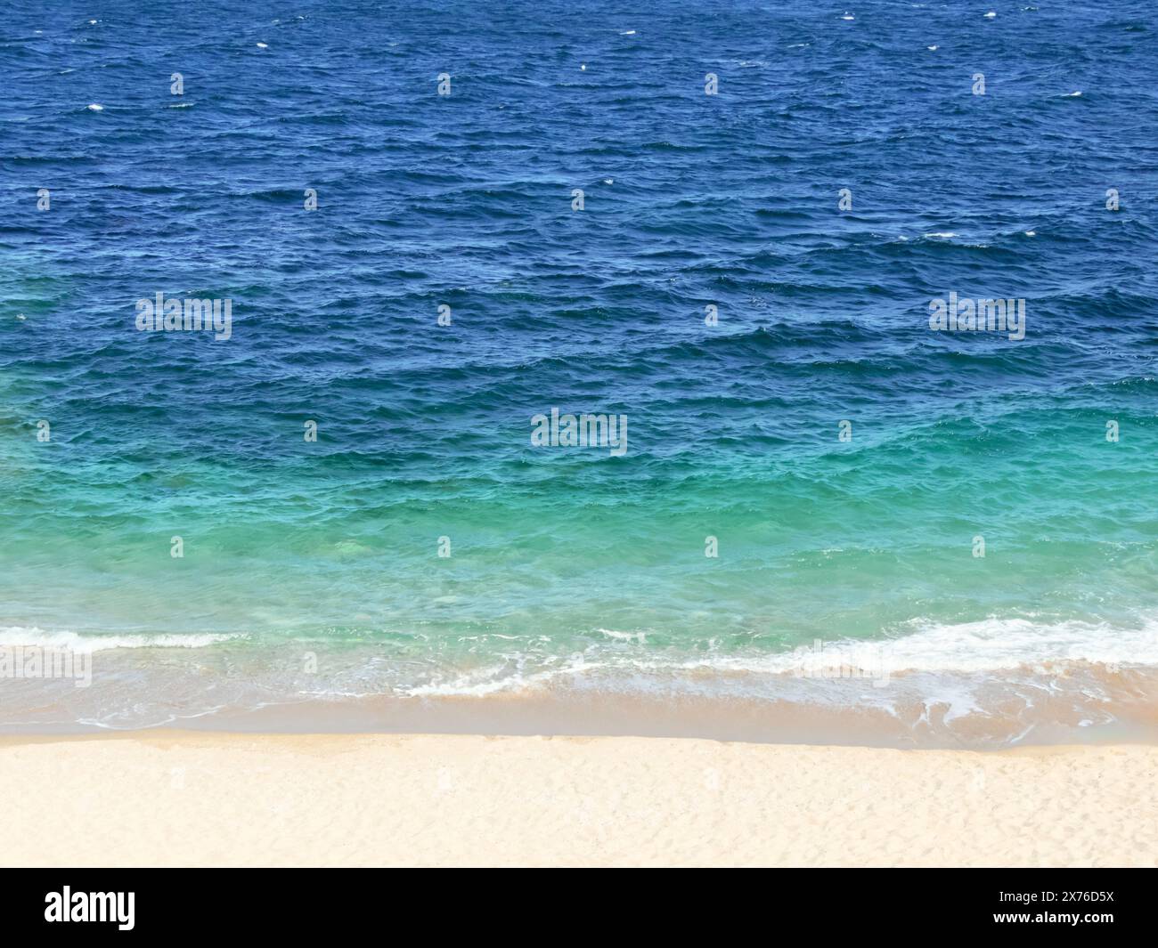 Kristallklares Dunkelblau und helles türkisfarbenes Meer und Sandstrand horizontaler Hintergrund. Ästhetische Tapete. Sommerurlaub oder Seefahrt. C Stockfoto