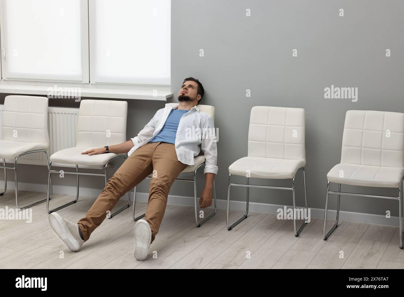 Müder Mann wartet drinnen auf das Vorstellungsgespräch Stockfoto