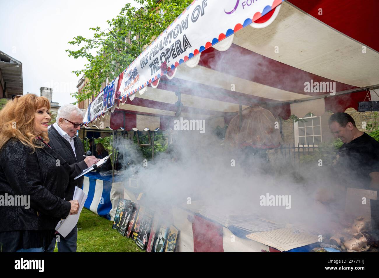 London, Großbritannien. 18. Mai 2024. Richter (L) Harriet Thorpe und Christopher Biggins am Phantom of the Opera Stand (mit Rauch) auf dem vierten West End Flohmarkt in den Gärten der St. Paul's Church, der Schauspielerkirche, in Covent Garden. Top West End Shows haben einzigartige Stände eingerichtet, um ihre Produktionen zu feiern und um den bestgekleideten Stand zu konkurrieren. Theatralische Erinnerungsstücke werden der Öffentlichkeit bei einer Veranstaltung angeboten, bei der Mittel zur Unterstützung von Schauspielern für andere gesammelt werden, die 14 britischen Theater- und Wohlfahrtsverbänden zugute kommen. Quelle: Stephen Chung / Alamy Live News Stockfoto