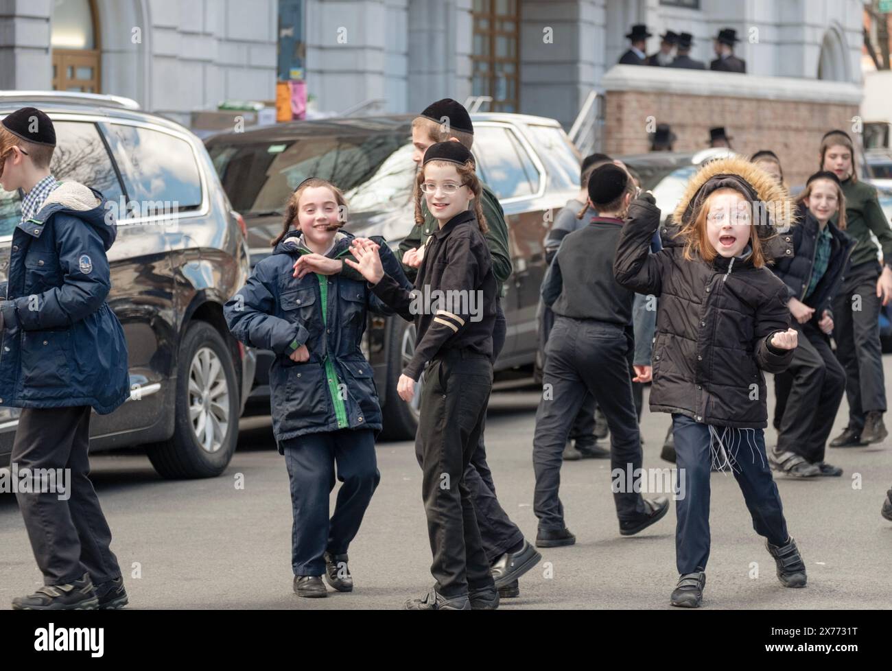 Während der Pause laufen orthodoxe jüdische Jeschiwa-Schüler im aktiven Spiel herum. In Brooklyn, Anfang Frühjahr 2024. Stockfoto