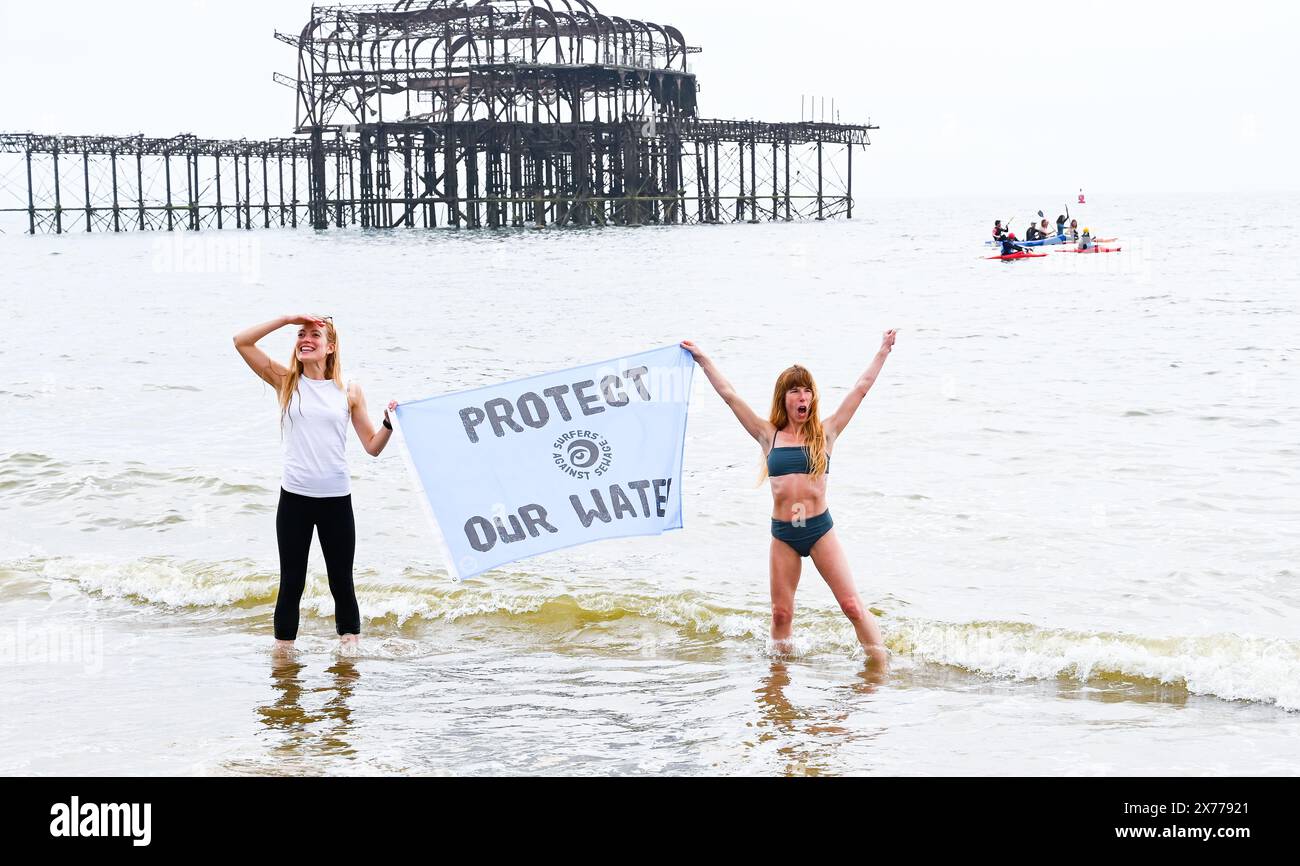 Brighton UK 18th May 2024 - die Surfer gegen Abwasser Protest von Brighton West Pier heute, als Hunderte von Paddelboardern und Schwimmern auf das Meer gehen und sich für Wasserunternehmen einsetzen , um Abwasser in das Meer und die Wasserstraßen um Großbritannien zu pumpen . Credit Simon Dack / Alamy Live News Stockfoto