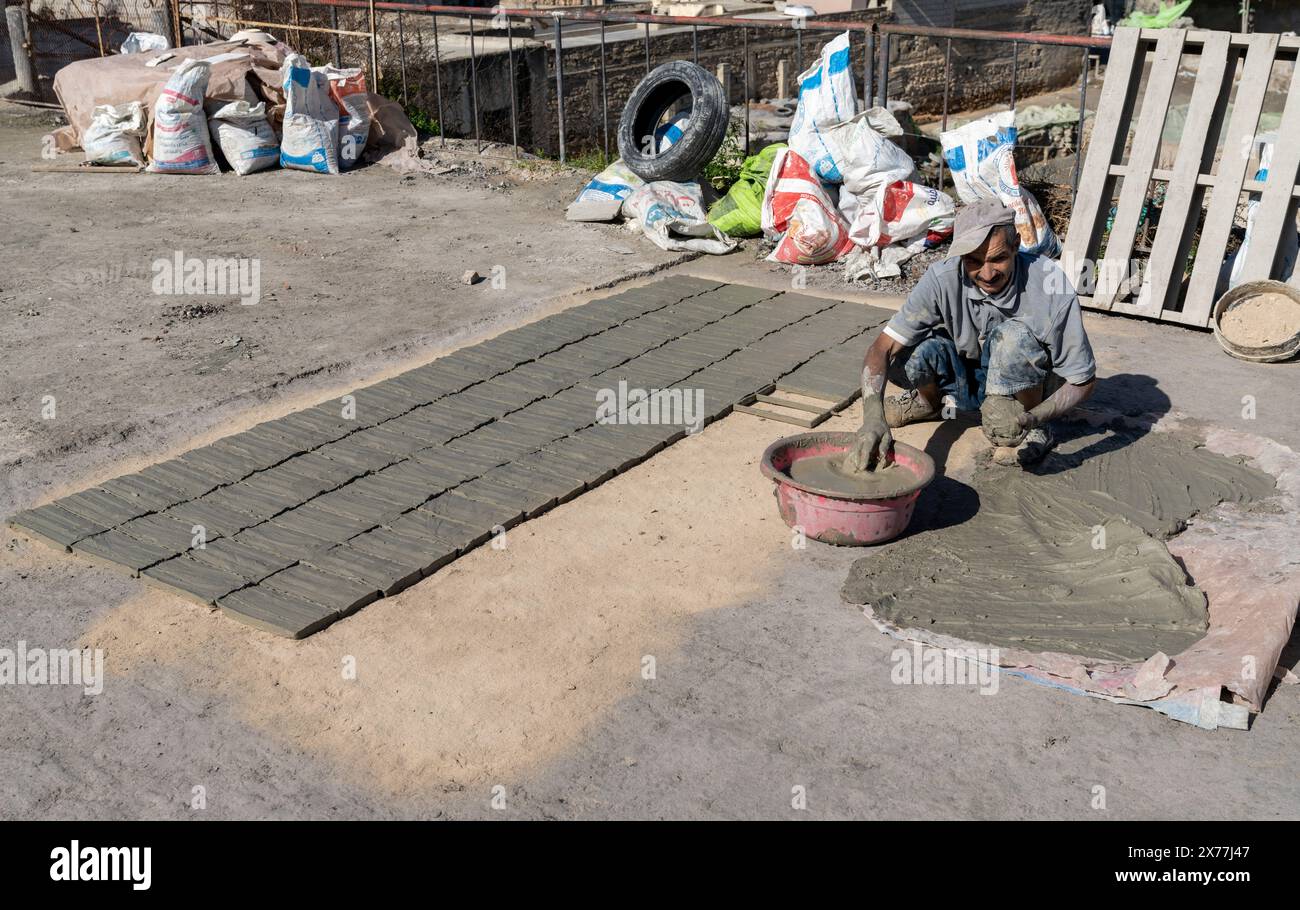 Fès, Marokko - 4. März 2024: Arbeiter, die Ton- und Zementziegel auf traditionelle Weise in einer Fabrik im unteren Fès herstellen Stockfoto