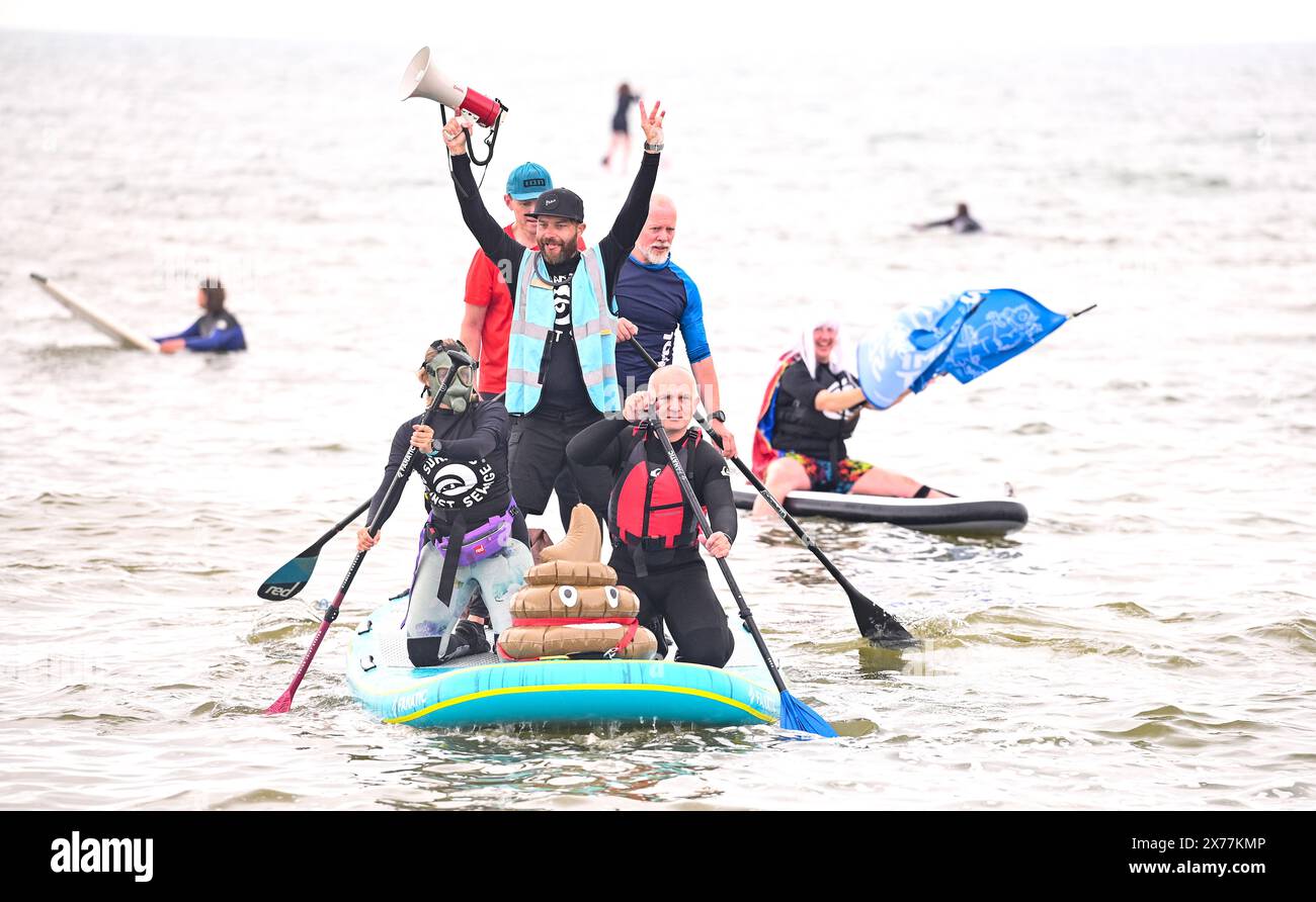 Brighton Großbritannien 18. Mai 2024 - die Surfer gegen Abwasser protestieren heute am West Pier von Brighton, als Hunderte von Paddelboardern und Schwimmern auf das Meer gehen und sich für Wasserunternehmen einsetzen, damit sie nicht mehr Abwasser ins Meer und in die Wasserstraßen um Großbritannien pumpen. Credit Simon Dack / Alamy Live News Stockfoto