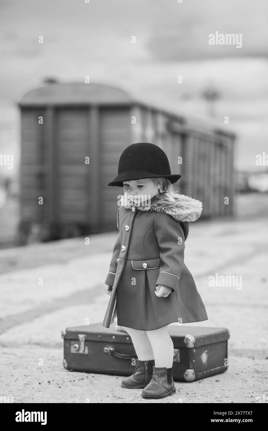 Retro-Foto eines kleinen Mädchens, das auf einen Zug wartet Stockfoto