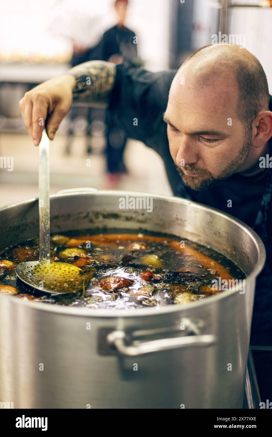 Der Koch probiert Suppe in der kommerziellen Küche Stockfoto