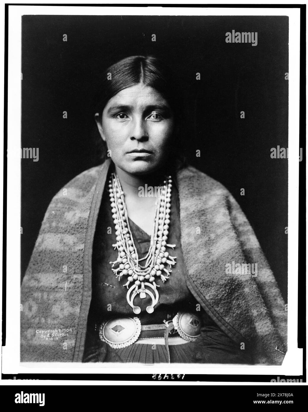 Kopf-und-Schultern-Porträt der Navajo-Frau, mit Blick auf die Vorderseite, Edward S. Curtis Collection 1019.. Indianer von Nordamerika, Frauen, 1900-1910. Navajo Indianer, Frauen, 1900-1910. Navajo Indians, Kleidung & Kleidung, 1900-1910. Stockfoto