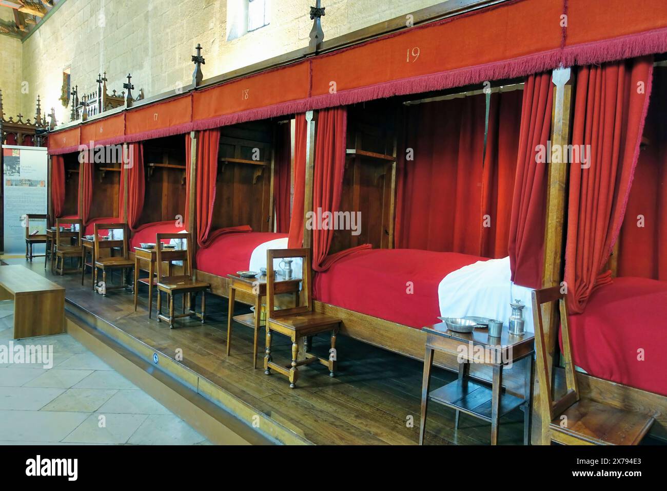 BEAUNE, FRANKREICH - 13. MAI 2024: Inneneinrichtung mit Betten und roten Decken aus Hospiz und Museum l'Hotel-Dieu, in Beaune, Frankreich Stockfoto