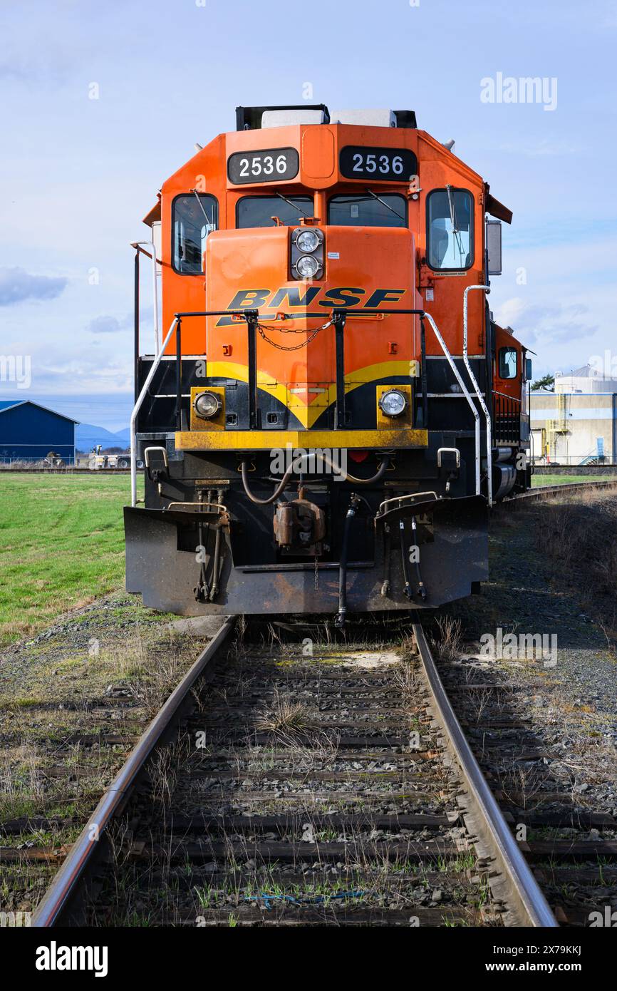 Mount Vernon, WA, USA - 2. Februar 2024; orangene BNSF GP39-3 Lokomotiven warten auf Arbeit in einem Anschlussgleis mit gekrümmtem Gleis Stockfoto