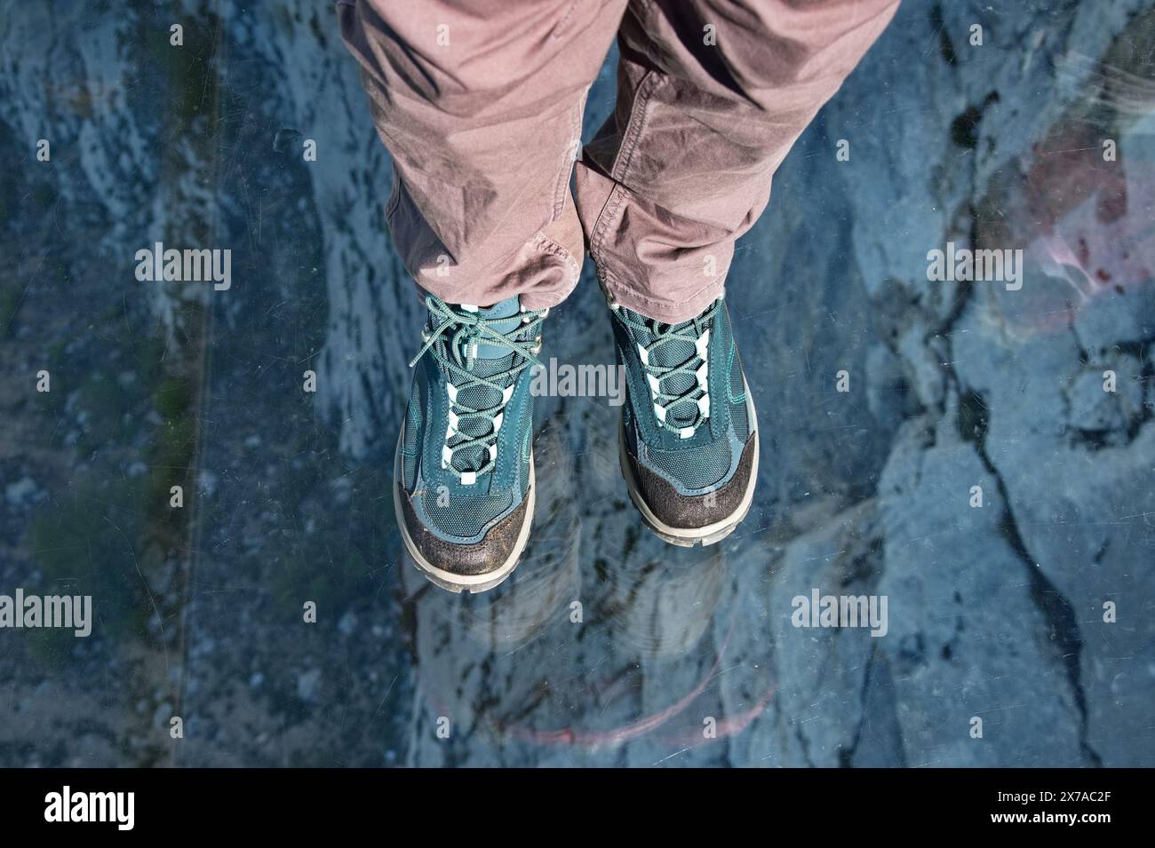 Hochwinkelansicht der Füße, die auf einer transparenten Glasplattform stehen Stockfoto