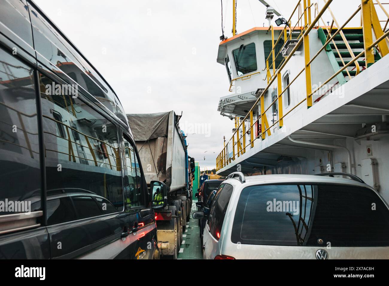 Autos, ein Van und ein Lastwagen auf dem Fährdeck von der Kurischen Nehrung nach Klaipėda, Litauen, an einem bewölkten Tag Stockfoto