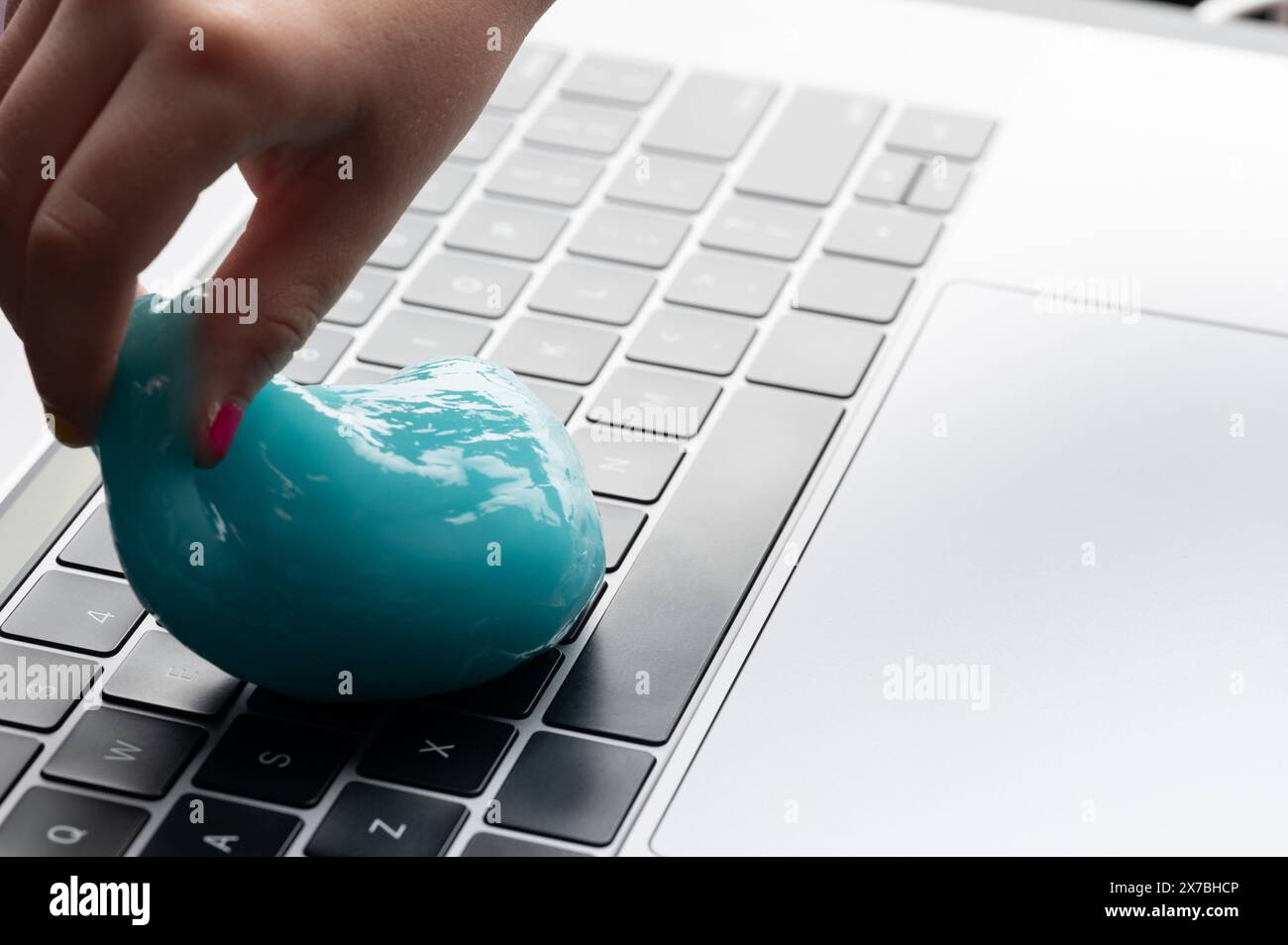 Blaue Gelmischung in der Hand zur Reinigung der Tastatur Stockfoto