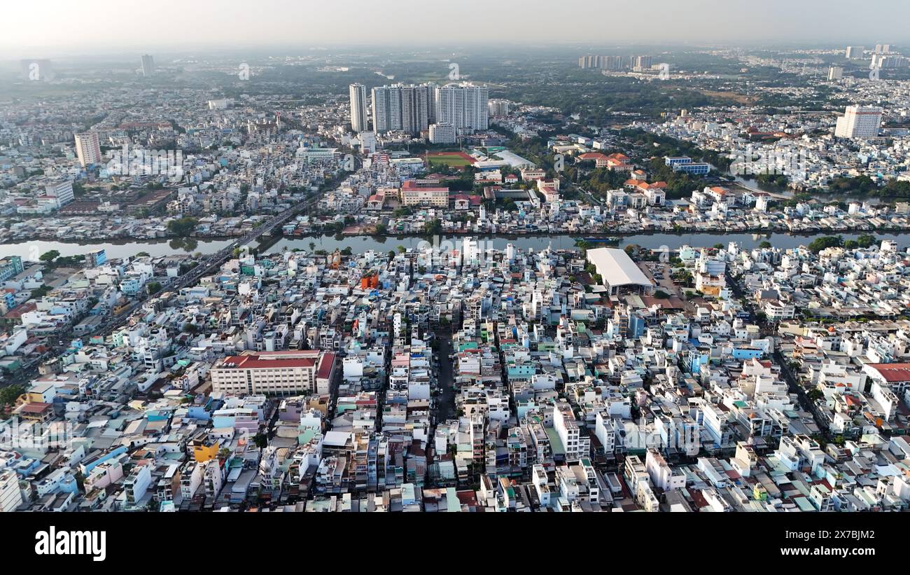 Fantastischer Blick aus der Luft auf die große asiatische Stadt, Ho Chi Minh Szene, überfülltes Stadthaus am Fluss mit dichter Dichte, städtisch überbevölkert, Nguyen Tri Phuong Stree Stockfoto