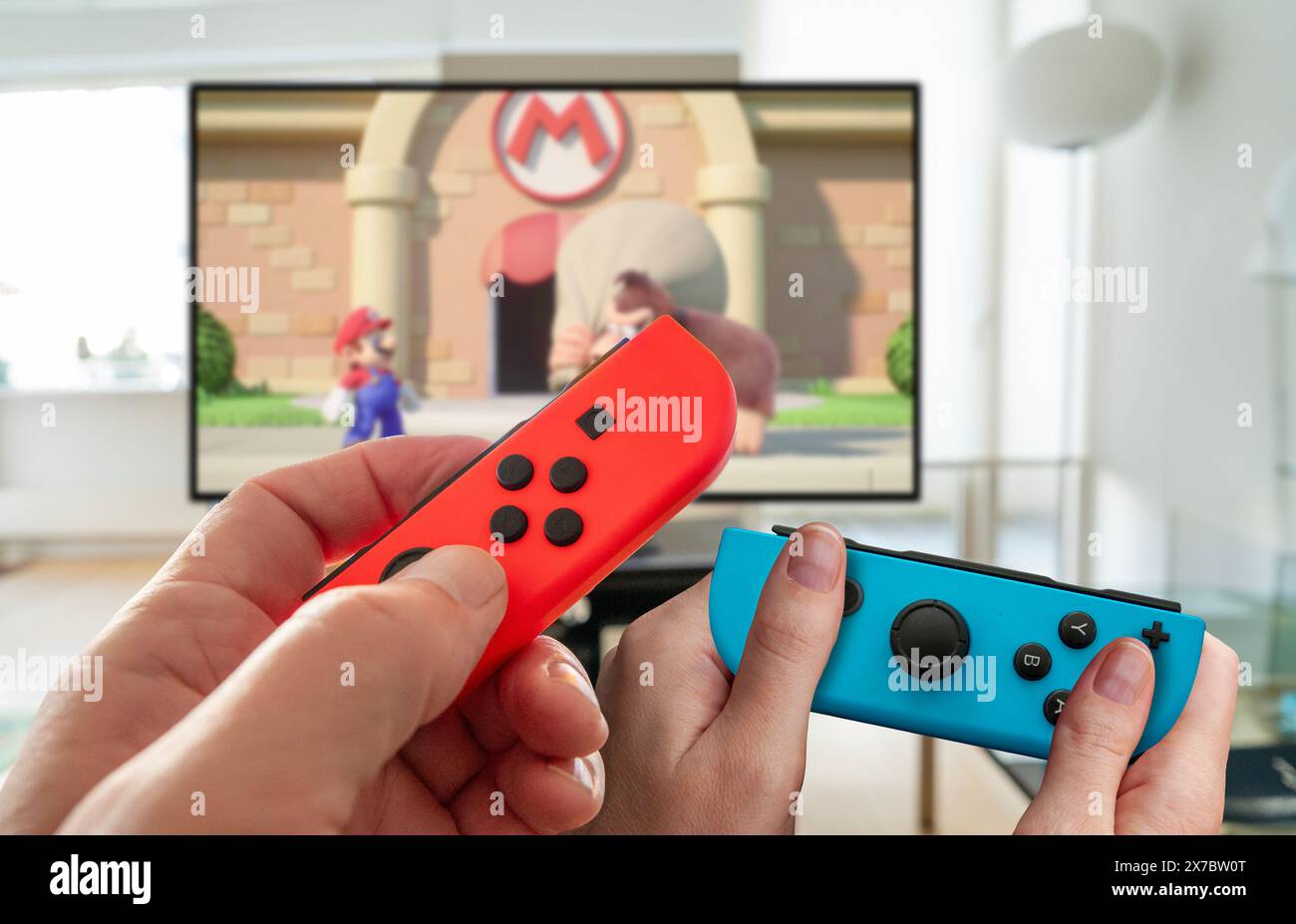 Nahaufnahme der Hände von Personen, die Mario vs. Donkey Kong auf einer neuen Nintendo Switch-Konsole im Handheld-Modus spielen. Beliebte mobile Konsole. Kopenhagen, Denma Stockfoto