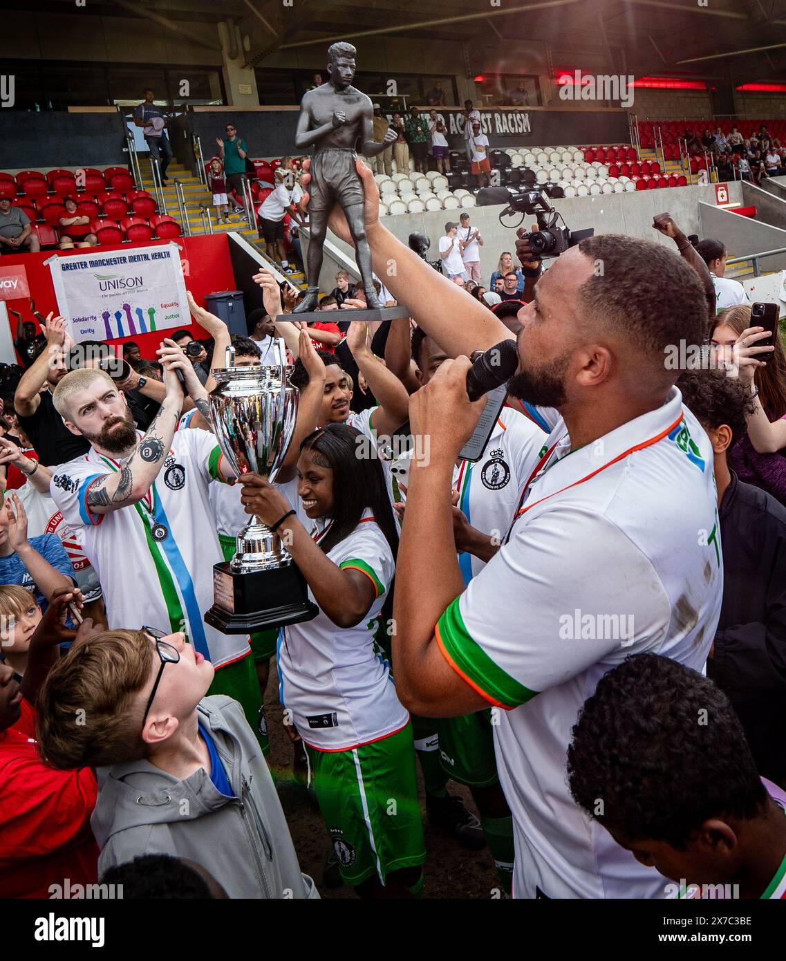 Manchester, Großbritannien. Mai 2024. Lamin Touray mit Statue beim Fußballspiel von Len Johnson gegen den FC United Legends im Broadhurst Park Stadium. Das Spiel wird organisiert, um den ehemaligen Boxmeister Len Johnson zu würdigen und Geld für eine geplante Statue in Manchester zu sammeln. An dem Spiel nahmen zahlreiche Prominente Teil, wie die Mancunian-Rapperin Lady Ice, der beliebte YouTuber Angry Ginge, der Schauspieler Lamin Touray und der Auszubildende Star Kayode Damali. Picture Garyroberts/worldwidefeatures.com Credit: GaryRobertsphotography/Alamy Live News Credit: GaryRobertsph Stockfoto