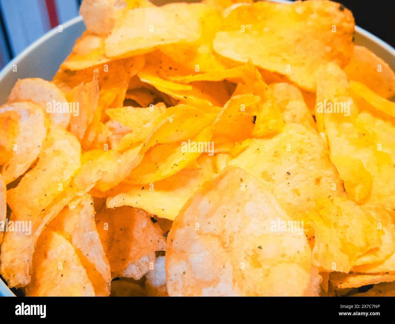Party-Chips. Knusprige Chips vor verspieltem Hintergrund, geeignet für Partyessen. Stockfoto
