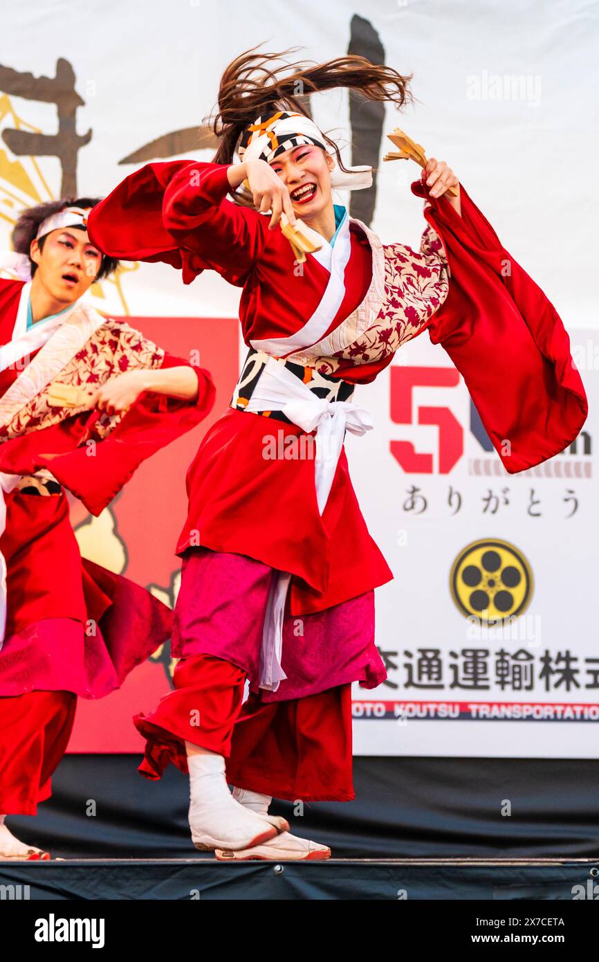 Teenagerin Yosakoi Tänzerin in langärmligen roten Yukata, auf der Bühne und mit Naruko, Holzklatschen, während des Kumamoto Kyusyu Gassai Festivals. Stockfoto