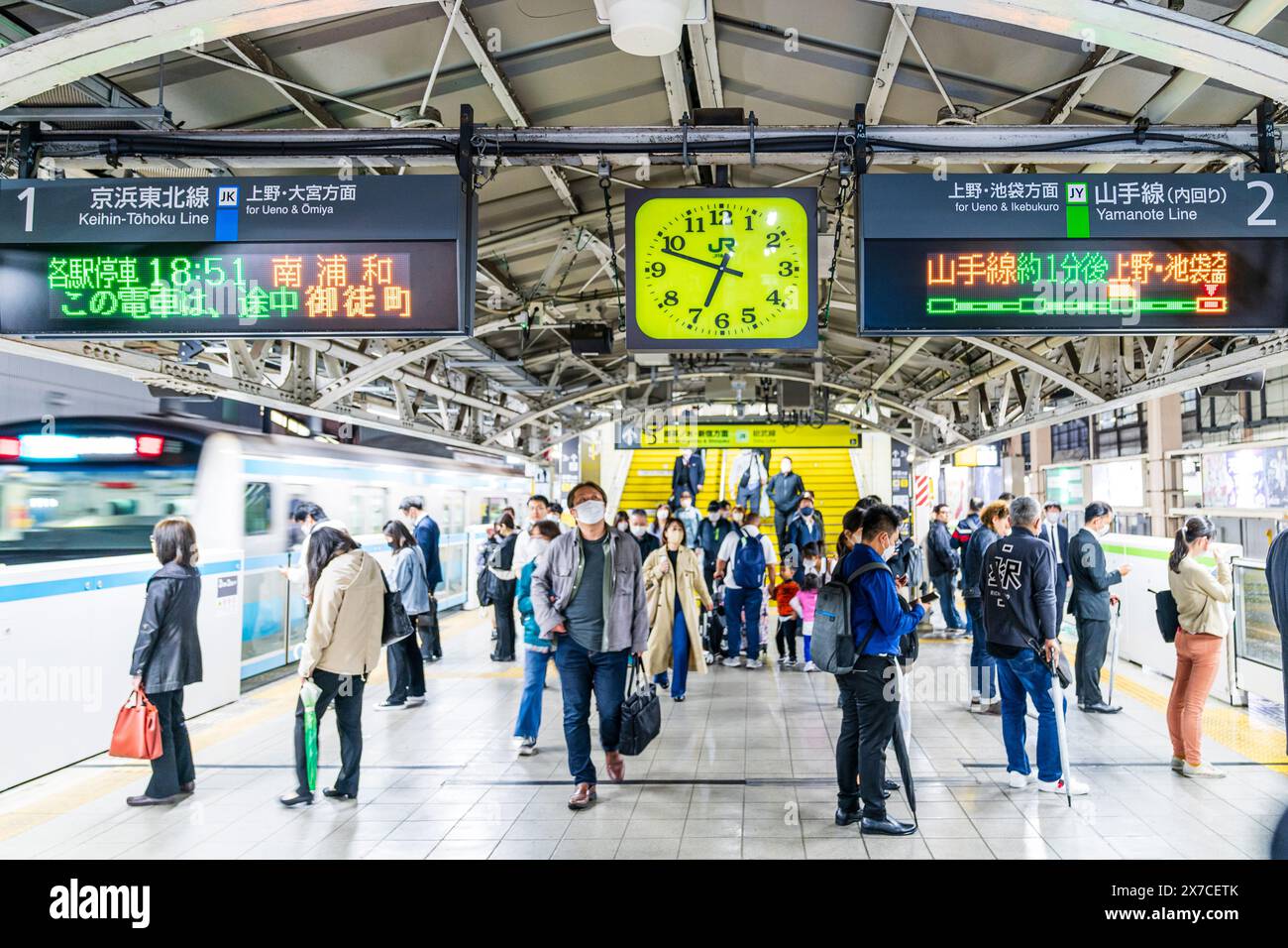 Blick entlang des Bahnsteigs am Bahnhof Akihabara auf der Yamanote-Linie am Abend. Zugabfahrt, selektiver Fokus auf Beschilderung über den Tokioter Linien. Stockfoto