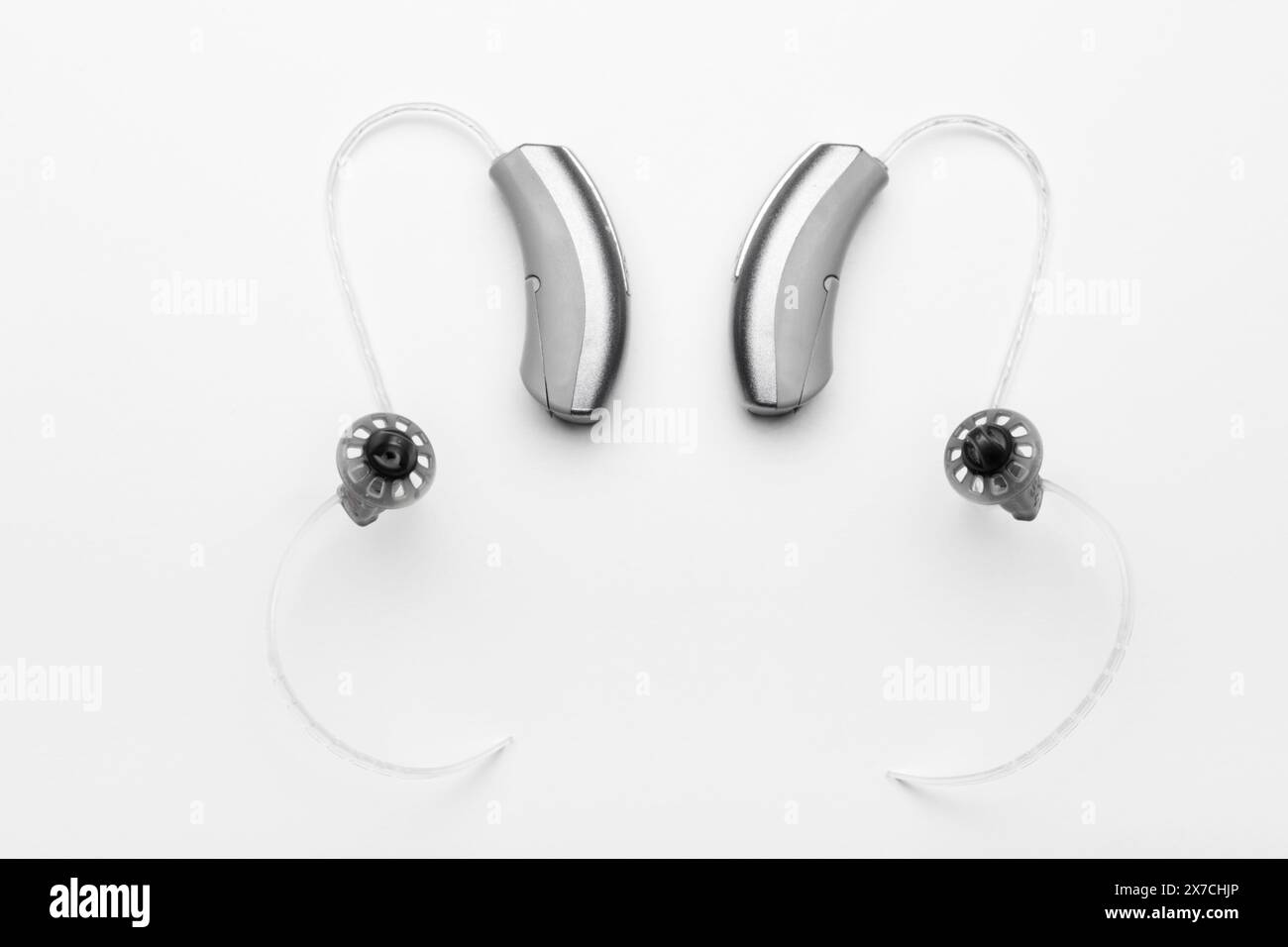 Nahaufnahme kleiner moderner Hörgeräte auf weißem Hintergrund Stockfoto