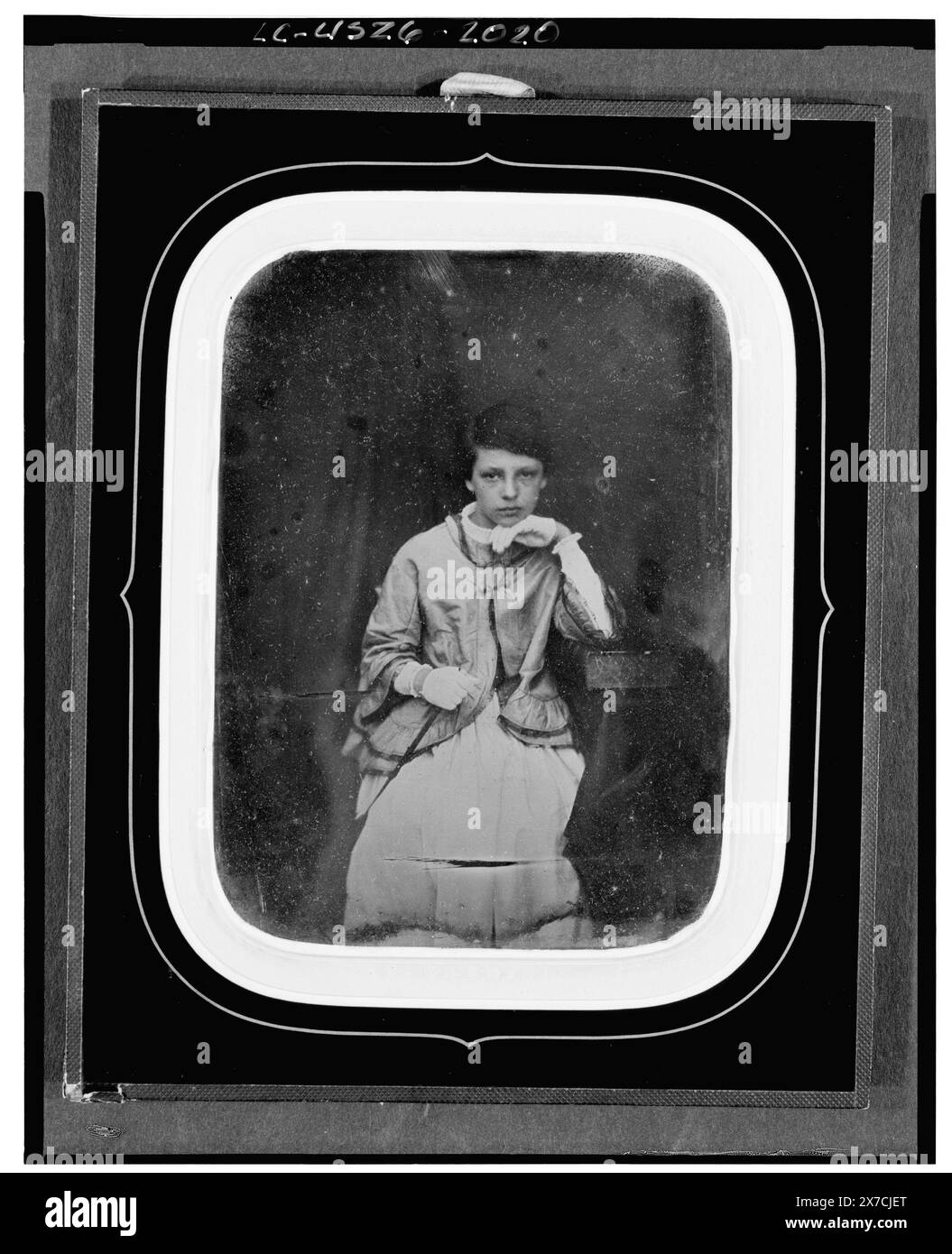 Nicht identifiziertes Mädchen, Porträt dreiviertel Länge, nach vorne gerichtet, mit Ellenbogen auf großem Buch auf Tisch gesetzt, Fotograf unidentifiziert., in Passepartout-Matte, Geschenk; Charles W. Millard; 1976; (DLC/PP-1976:096)., ist Teil von : Sammlung von Daguerreotypen , . Stockfoto
