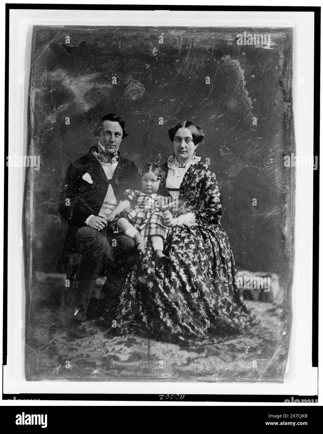 Nicht identifizierter Mann und Frau, beide etwa 30 Jahre alt, mit einem Kind etwa zwei Jahre alt, das auf dem Knie der Frau sitzt, in voller Länge Porträts, nach vorne gerichtet, auf Stühlen auf Teppich sitzend, auf der Rückseite des Tellers zerkratzt: 178; 196., zwei Kanten beschnitten., Transfer; U.S. war College; 1920; (DLC/PP-1920:46153)., ist Teil der Daguerreotype Collection, produziert von Mathew Bradys Studio. Stockfoto