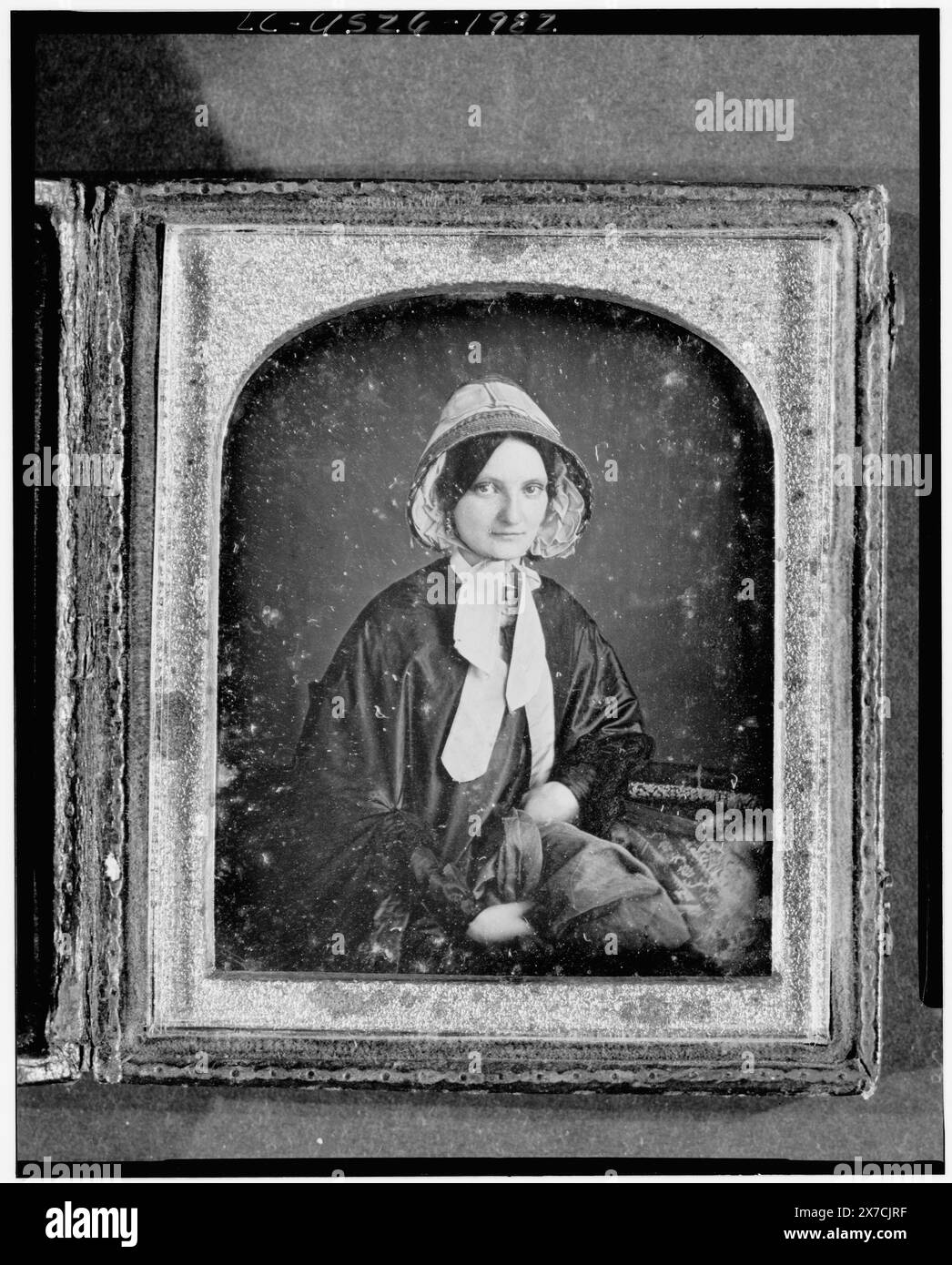 Nicht identifizierte Frau, Dreiviertelformat, nach vorne gerichtet, mit Haube, Arm auf Tisch mit Tischdecke; Bücher auf Tisch, Fotograf unidentifiziert., Fall: Variante von Rinhart 123., Quelle unbekannt., gehört zu: Daguerreotype-Sammlung , . . . . . . . . . . . . . . . . . . . . . . . . . . . . . . . . . . . . . Stockfoto