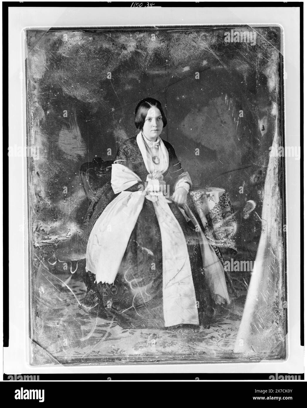 Nicht identifizierte Frau, Porträt in voller Länge, Dreiviertel rechts, im Stuhl an einem kleinen Tisch mit Tischdecke sitzend, alternative Identifikation: Frau Knox Walker (Augusta Adams Tabb Walker, Ehefrau von Joseph Knox Walker)., auf Platte gekratzt: 188; Frau Knox Walker, Pin. Kratzer auf der Rückseite der Platte: 239., Transfer; U.S. war College; 1920. (DLC/PP-1920:46153)., ist Teil der Daguerreotype Collection, produziert von Mathew Bradys Studio. Stockfoto