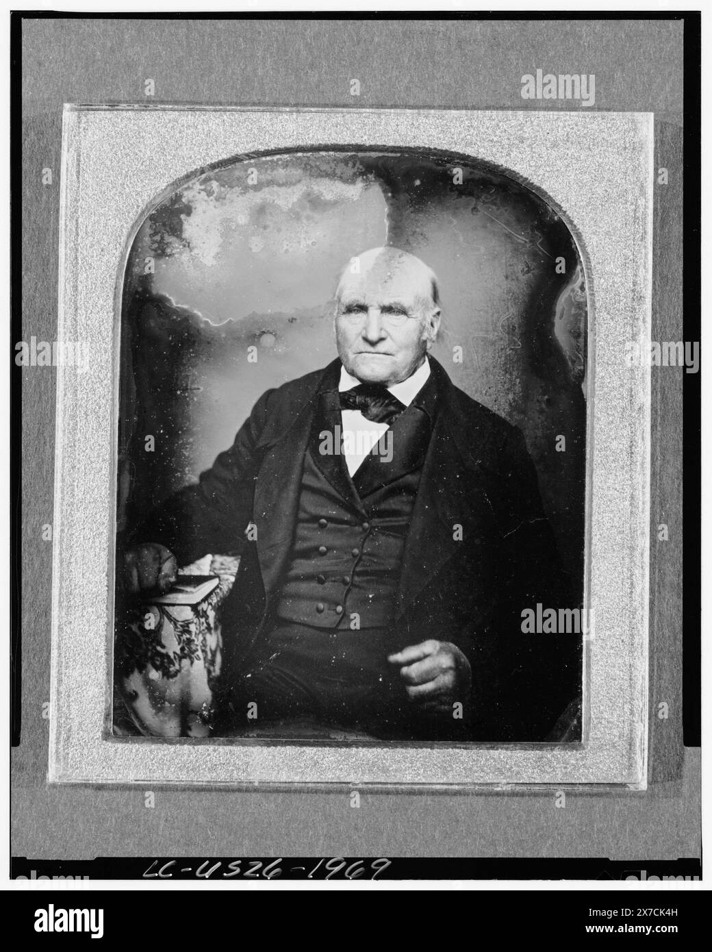 Unbekannter Mann, Dreiviertelporträt, nach vorne gerichtet, neben Tisch mit Tischdecke sitzend, Buch in der Hand, Fotograf unbekannt., Hallmark: Rinhart 13A., Fall: Variante von Rinhart 219., Quelle unbekannt., gehört zu: Daguerreotype-Sammlung , . Stockfoto