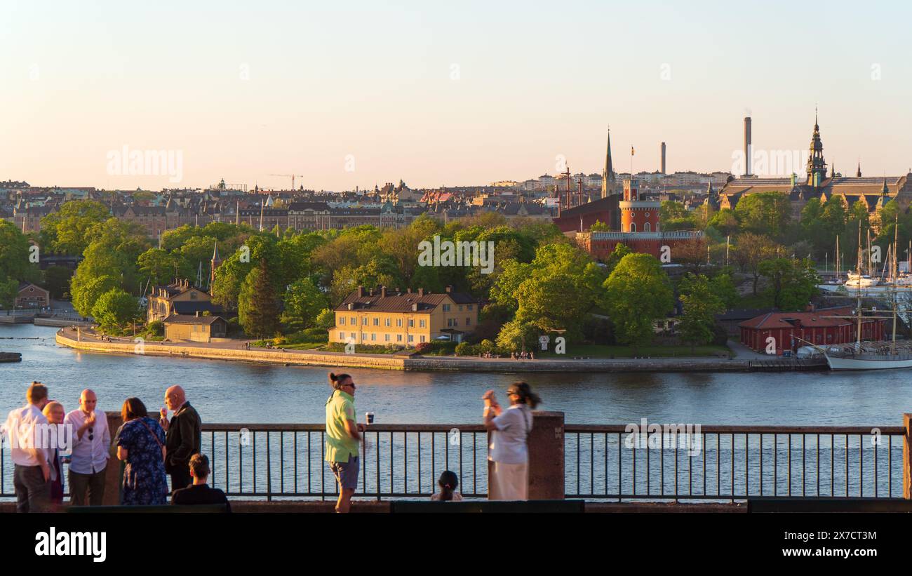 Touristen und Einheimische am Aussichtspunkt Fjällgatan Street mit Blick auf die Stockholmer Inlet kastellholmen, Skeppsholmen, Djurgården und Nordisches Museum. Stockfoto