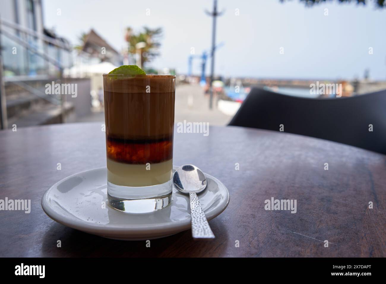 Barraquito, kanarischer Kaffee auf einem Tisch am Meer. Stockfoto