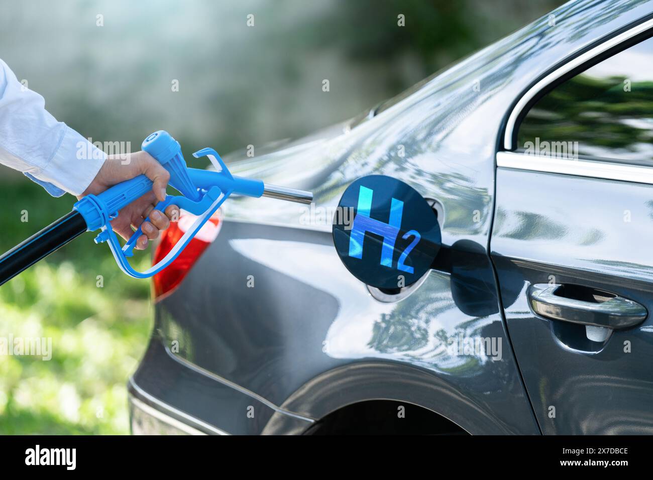 Der Mann hält eine Wasserstoffdüse. Betanken des Autos mit Wasserstoffkraftstoff. Konzept... Stockfoto