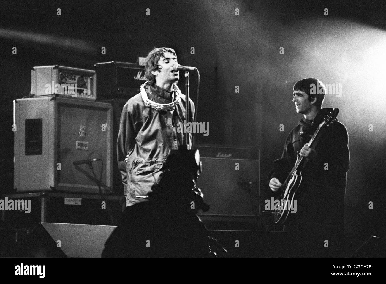 GALLAGHER BROTHERS, OASIS, ERSTE GLASTONBURY-HEADLINE, 1995: Liam (mit einem tamborine um den Hals) und Noel Gallagher von der Manchester-Band Oasis treten während des Encore auf, als sie die Hauptrolle auf dem Höhepunkt ihres Ruhmes beim Glastonbury Festival, Pilton Farm, Somerset, England, am 24. Juni 1995 spielten. 1995 feierte das Festival sein 25-jähriges Bestehen. In diesem Jahr gab es keine Pyramidenphase, da sie abgebrannt war. Foto: ROB WATKINS Stockfoto