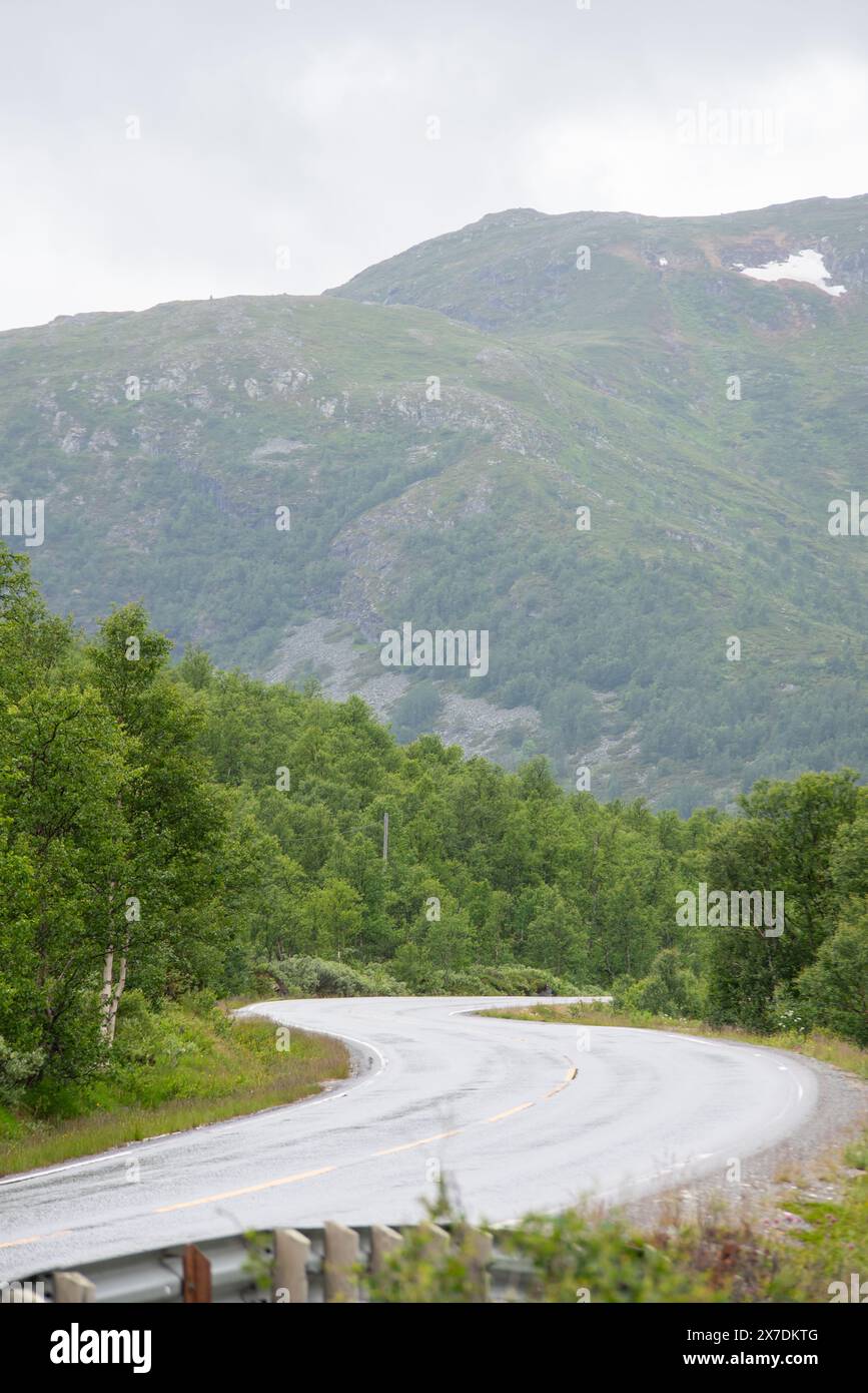Gewundene Bergstraße in Norwegen mit Blick auf große Fjorde an einem nebeligen, regnerischen Sommertag. Stockfoto