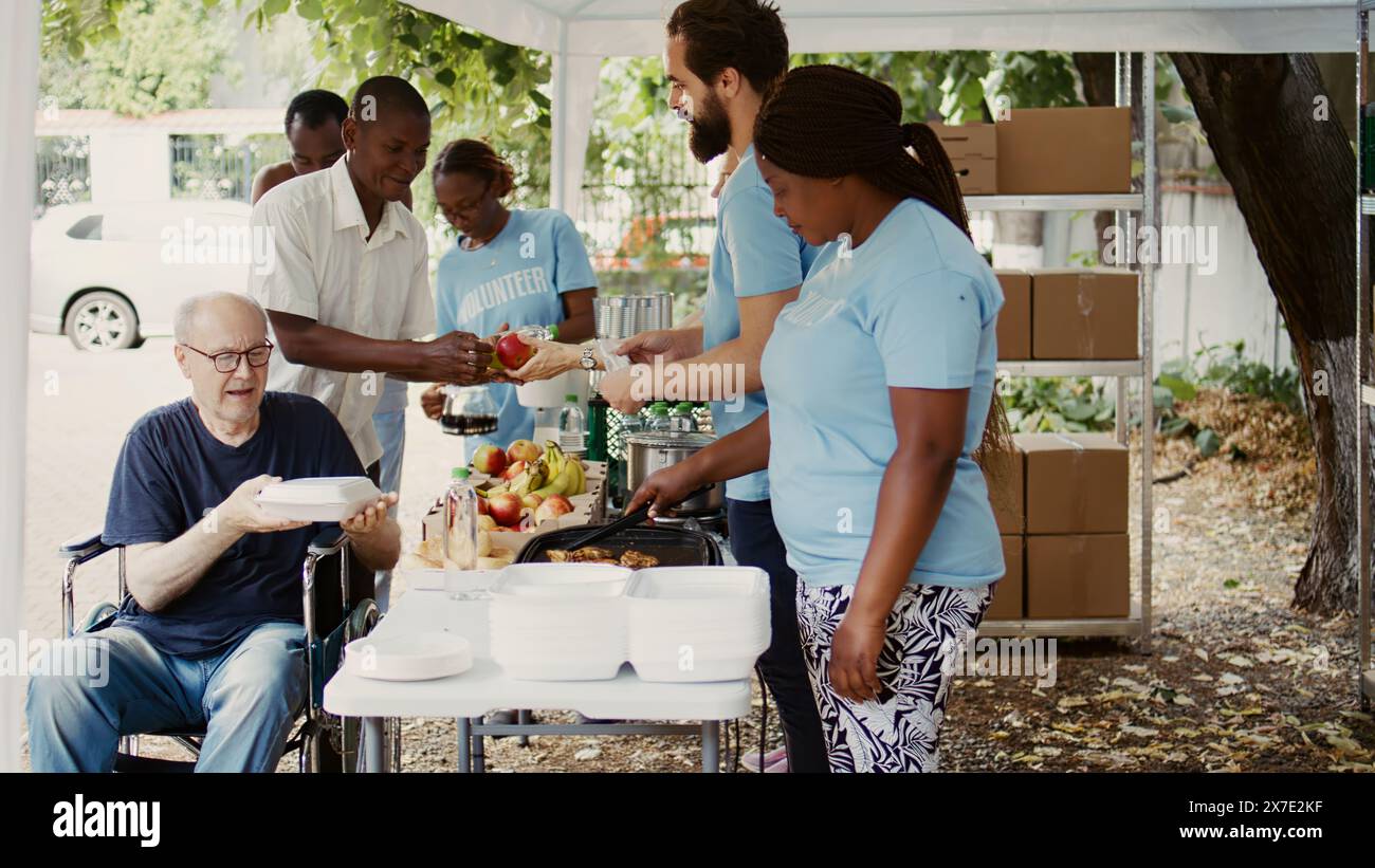 Die Gruppe widmet sich der Wohltätigkeitsorganisation, die den Armen hilft, kostenloses Essen einschließlich frischem Obst an Obdachlose zu verschenken. Freiwillige helfen dabei, den Hunger behinderter Menschen im Rollstuhl zu lindern. Stockfoto