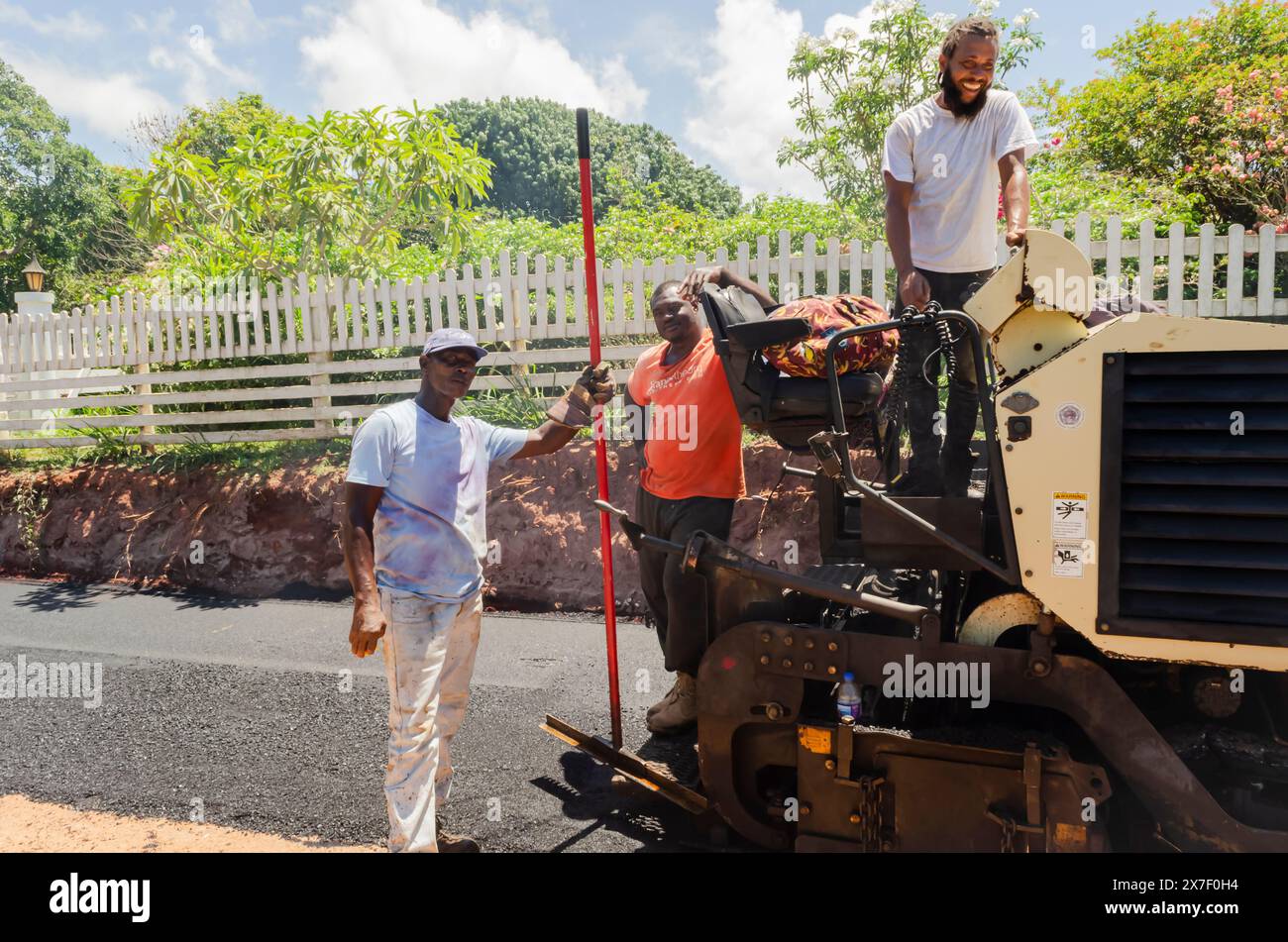 Ein Asphalt Concrete Paver and Men at Work bei Yardley Chase in Southfield, St. Elizabeth, repariert die Straße im Juli 2020 Stockfoto