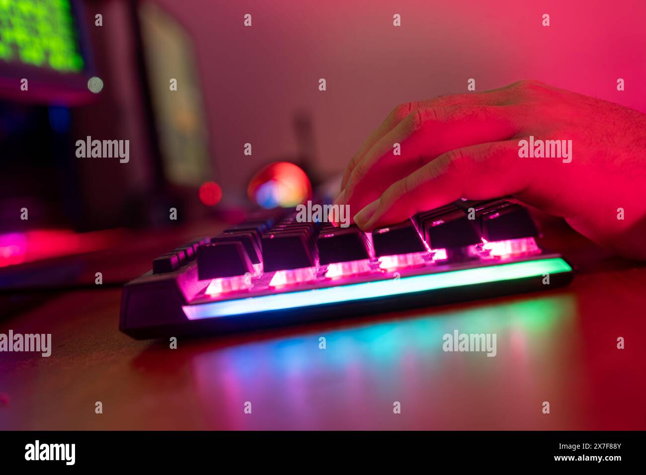 Professionelle online gamer Hand mechanische Tastatur in Neon Farben verwischen Hintergrund. Soft Focus, Ansicht von hinten. Stockfoto
