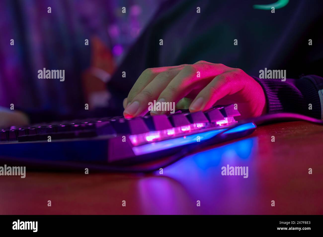 Professionelle online gamer Hand mechanische Tastatur in Neon Farben verwischen Hintergrund. Soft Focus, Ansicht von hinten. Stockfoto