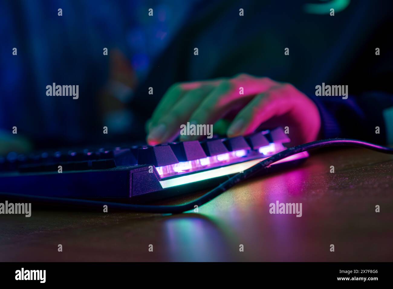 Professionelle online gamer Hand mechanische Tastatur in Neon Farben verwischen Hintergrund. Soft Focus, Ansicht von hinten. Stockfoto