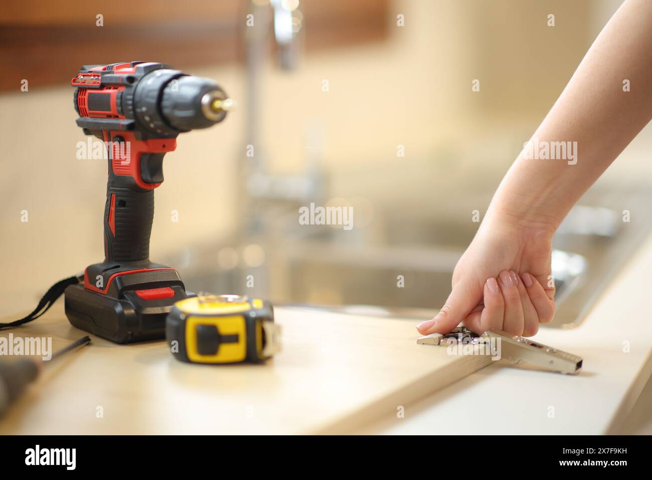 Frau, die Küchenmöbel in der Küche zu Hause zusammenbaut Stockfoto